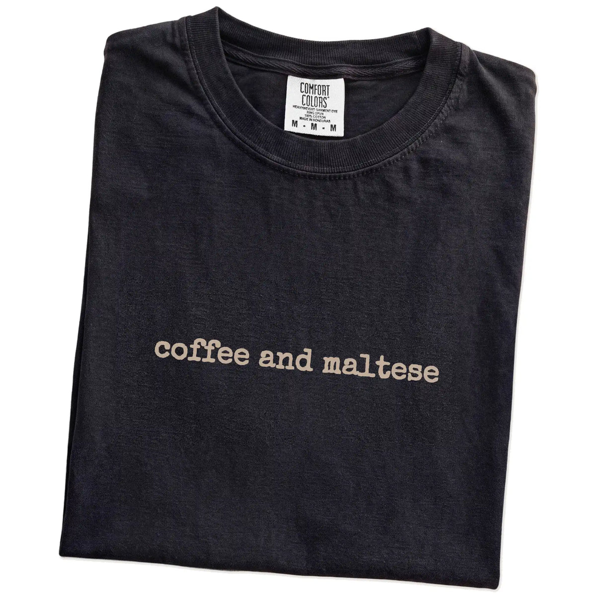 Folded Black Comfort Colors® T-shirt showing “coffee and maltese” retro text
