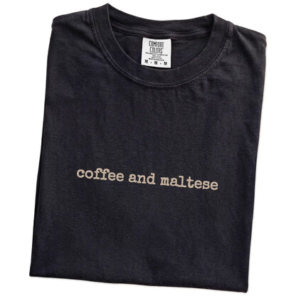 Folded Black Comfort Colors® T-shirt showing “coffee and maltese” retro text