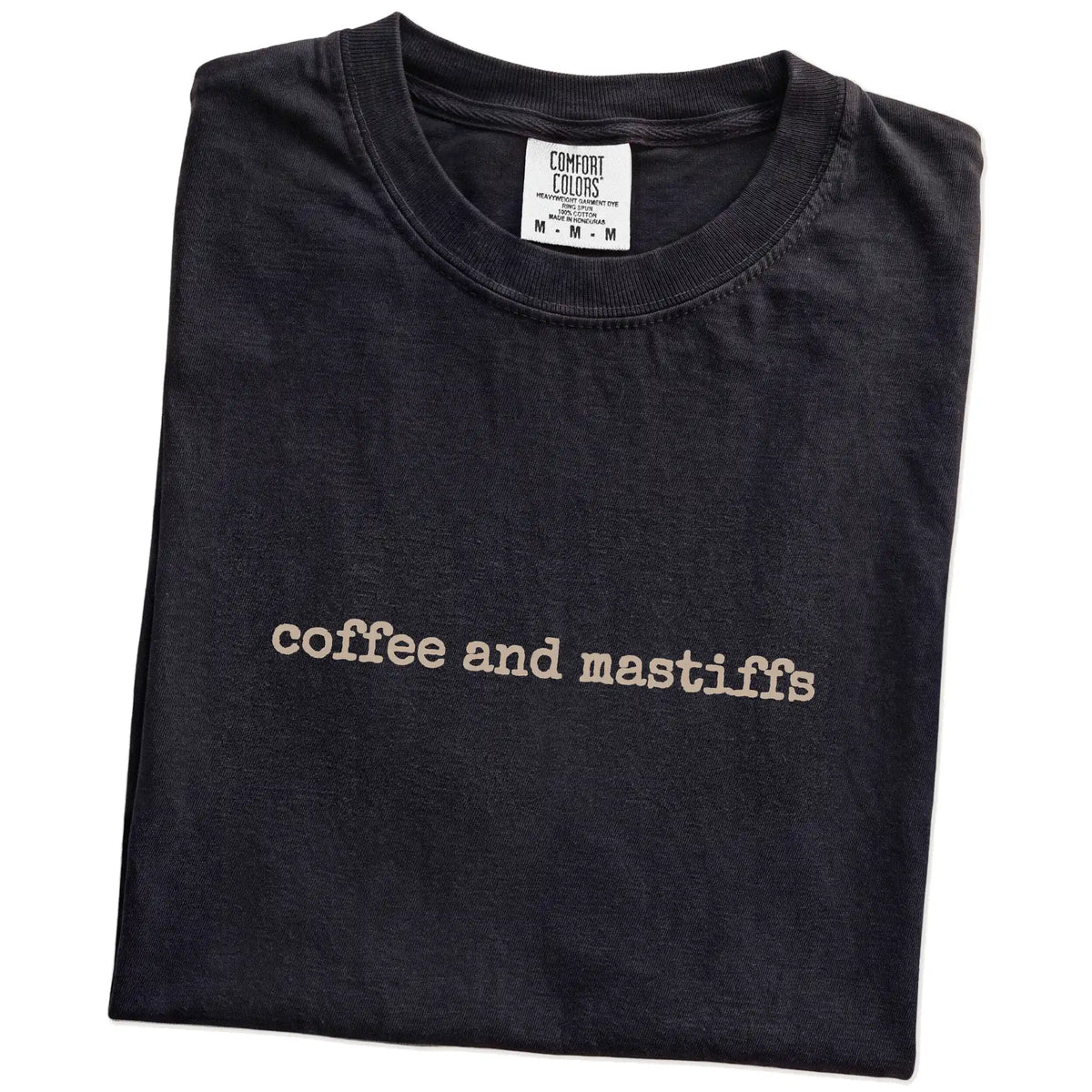 Folded Black Comfort Colors® T-shirt showing “coffee and mastiffs” retro text