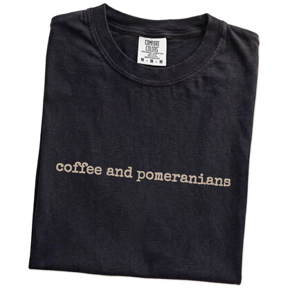 Folded Black Comfort Colors® T-shirt showing “coffee and pomeranians” retro text