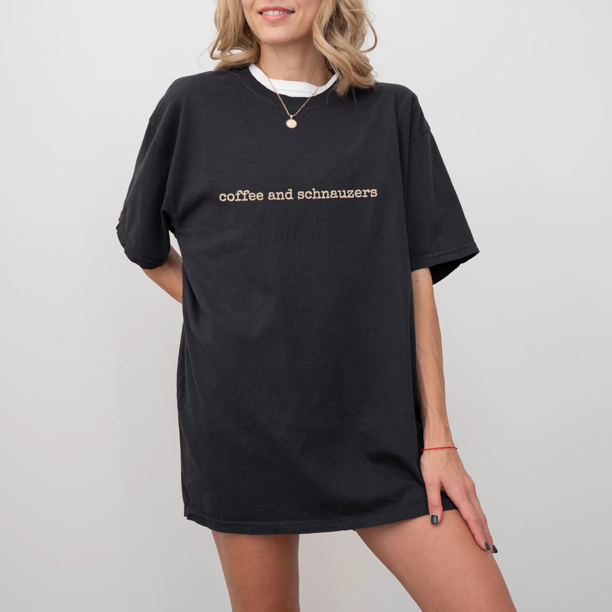 Model wearing a Black Comfort Colors® T-shirt with “coffee and schnauzers” retro text