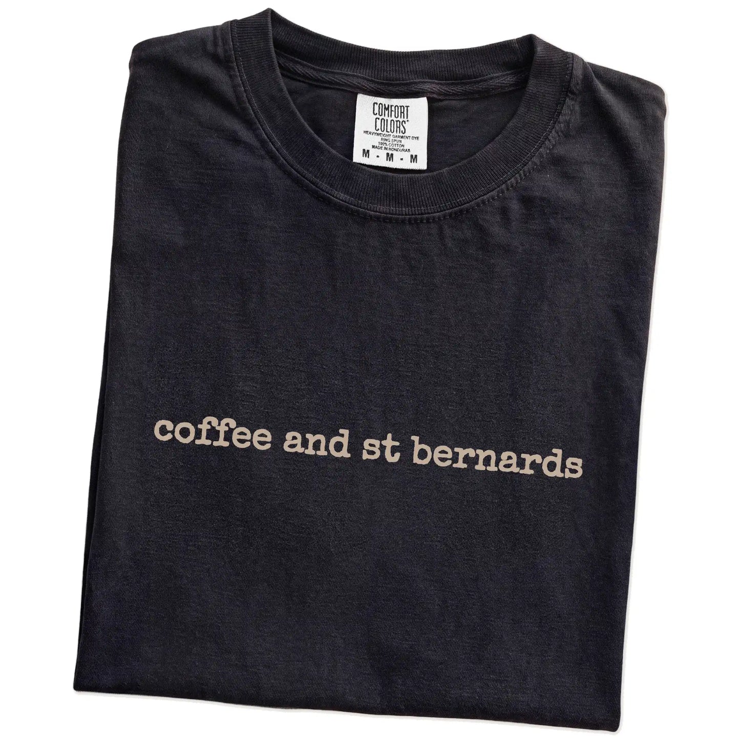 Folded Black Comfort Colors® T-shirt showing “coffee and st bernards” retro text