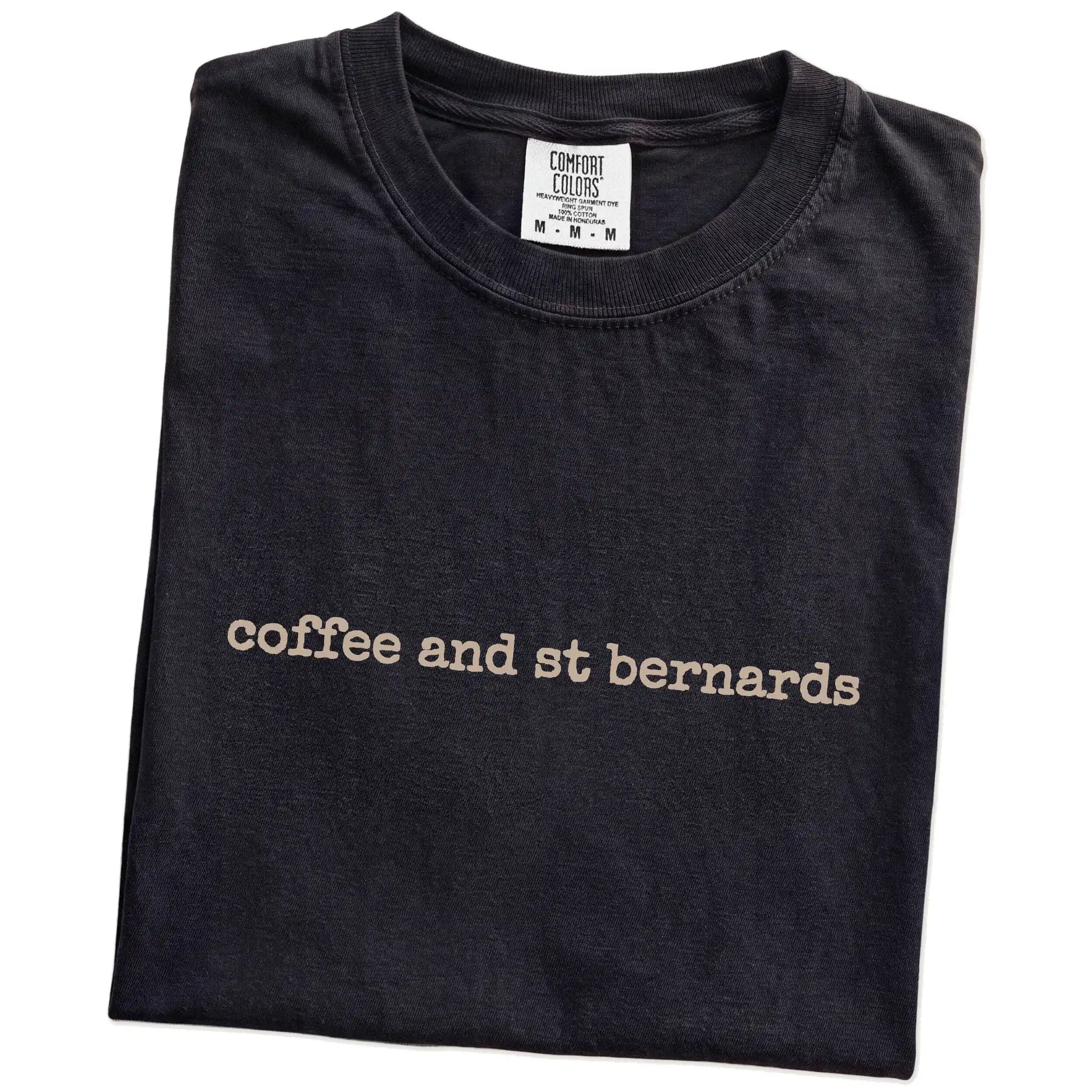 Folded Black Comfort Colors® T-shirt showing “coffee and st bernards” retro text