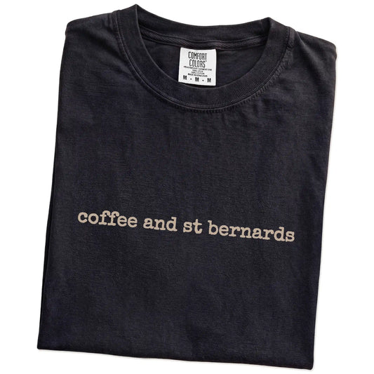 Folded Black Comfort Colors® T-shirt showing “coffee and st bernards” retro text
