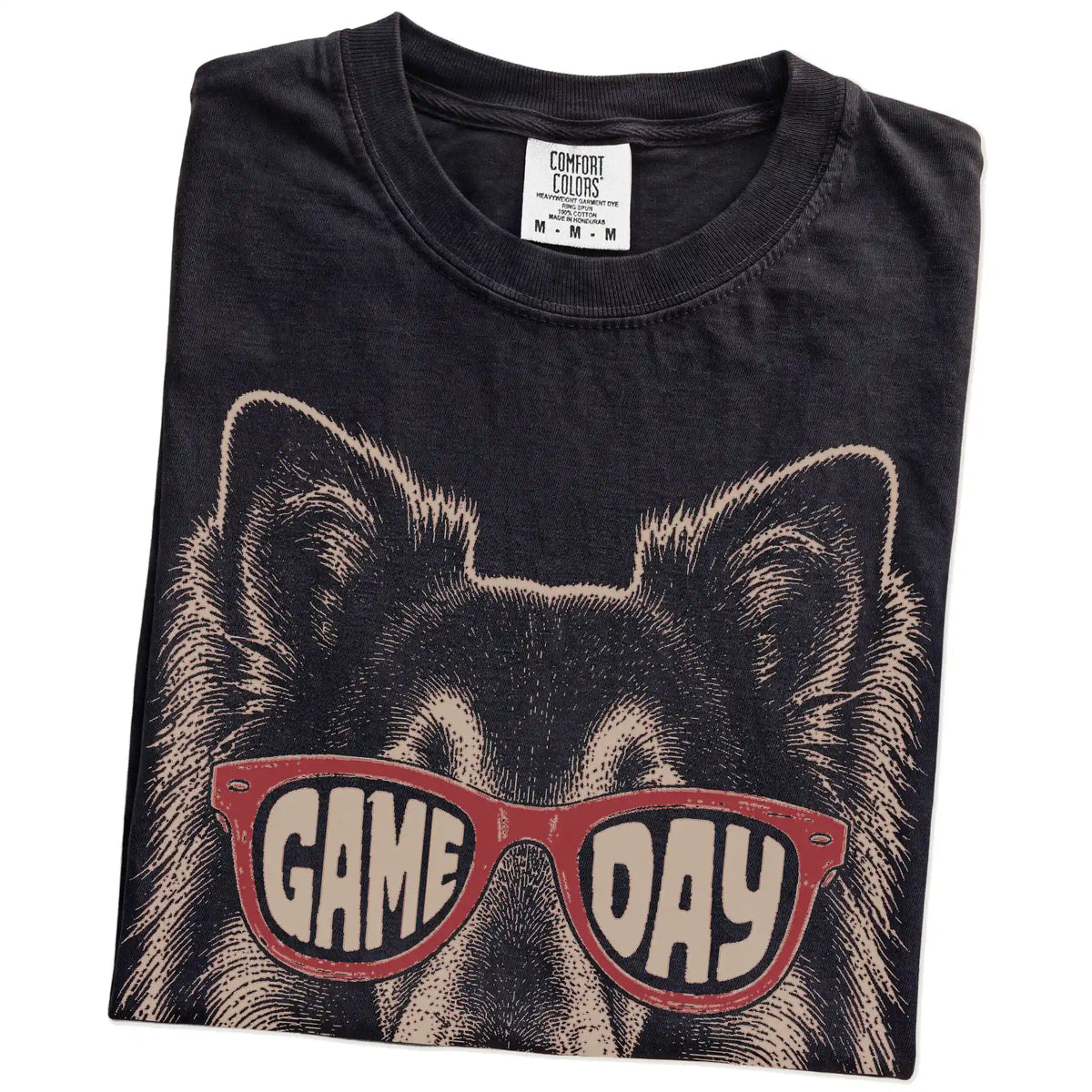 Folded Black Comfort Colors® T-shirt showing collie wearing red game day sunglasses