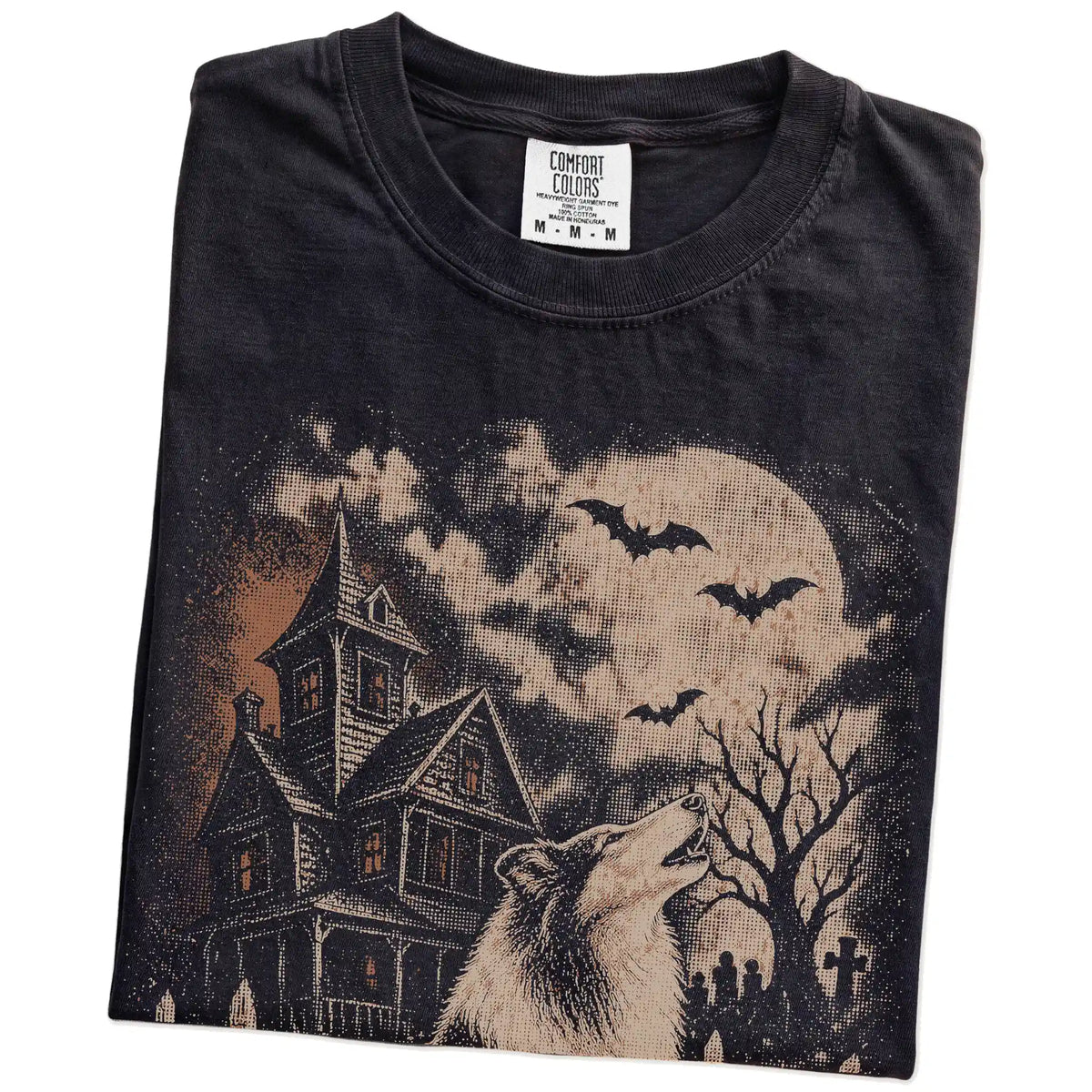 Folded Black Comfort Colors® T-shirt showing Collie in a vintage haunted-house scene