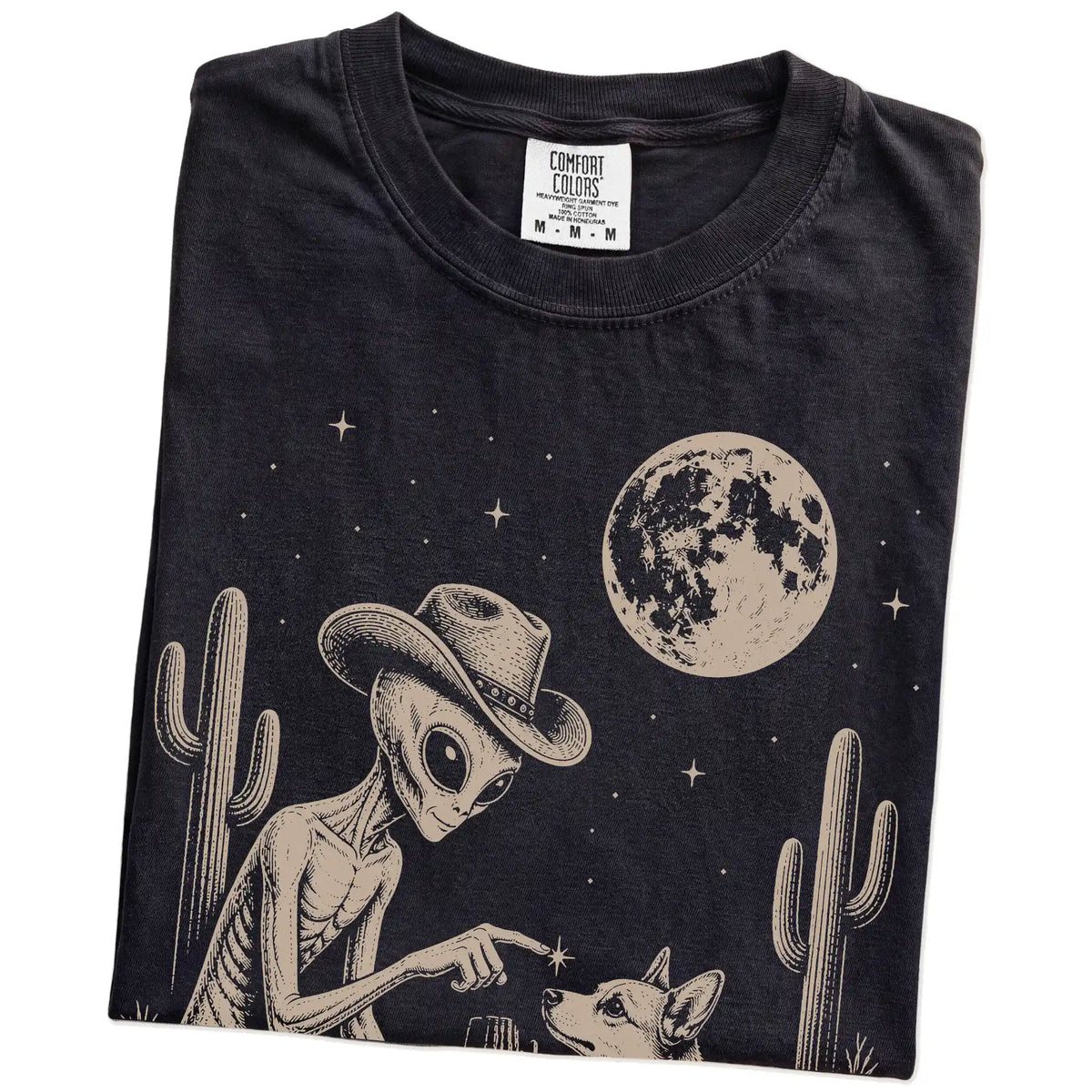 Folded Black Comfort Colors® T-shirt showing cowboy alien fist-bumping a corgi beneath the moon