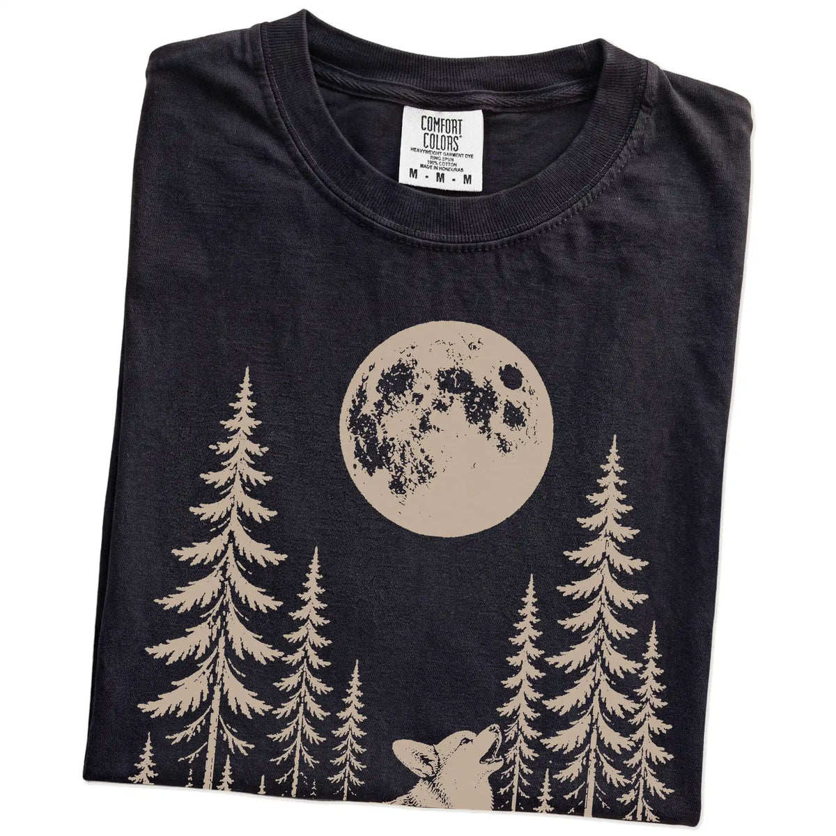 Folded Black Comfort Colors® T-shirt showing a Corgi howling beneath the moon and pine trees