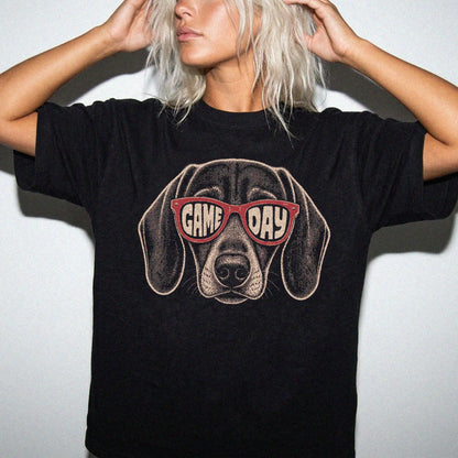 Model wearing a Black Comfort Colors® T-shirt with dachshund wearing red game day sunglasses
