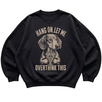 Black crewneck sweatshirt featuring Overthinking Dachshund, laid-flat presentation