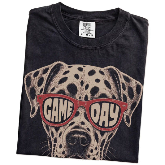Folded Black Comfort Colors® T-shirt showing dalmatian wearing red game day sunglasses