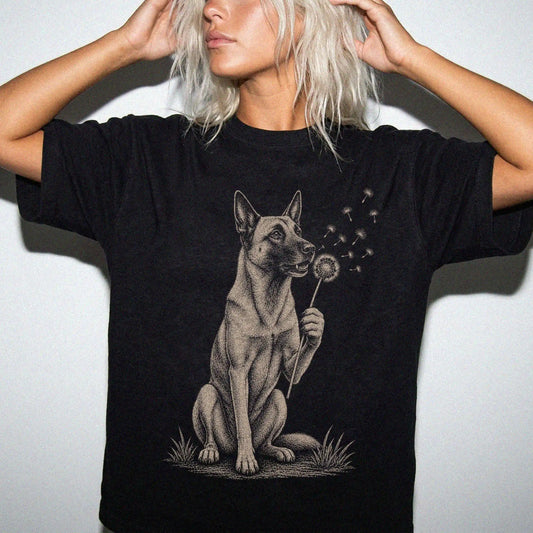 Model wearing a Black Comfort Colors® T-shirt showing Belgian Malinois portrait with drifting dandelion seeds
