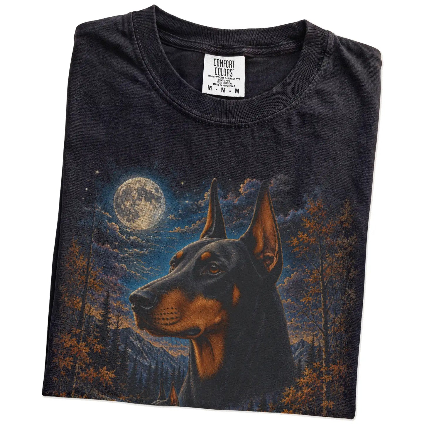 Folded Black Comfort Colors® t-shirt showing Doberman in a fall forest graphic