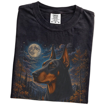 Folded Black Comfort Colors® t-shirt showing Doberman in a fall forest graphic