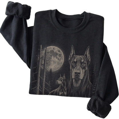 Folded black crewneck sweatshirt showing the Doberman Moonlit Forest graphic