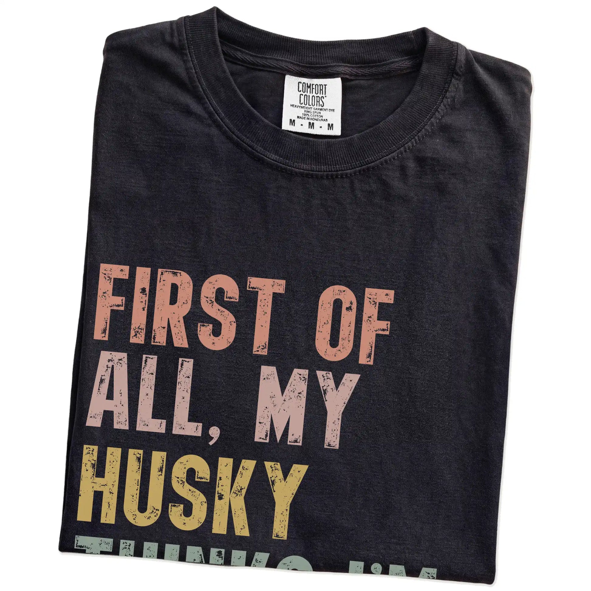 Folded Black Comfort Colors® T-shirt showing “My Husky thinks I’m delightful” text