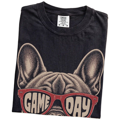 Folded Black Comfort Colors® T-shirt showing french bulldog wearing red game day sunglasses