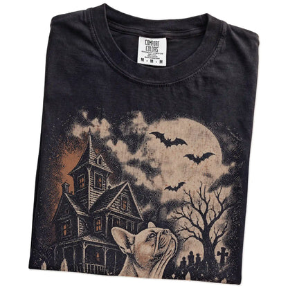 Folded Black Comfort Colors® T-shirt showing French Bulldog in a vintage haunted-house scene