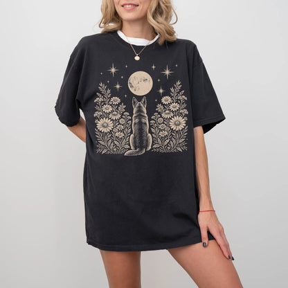 Model wearing a Black Comfort Colors® T-shirt featuring German Shepherd beneath a wildflower moon