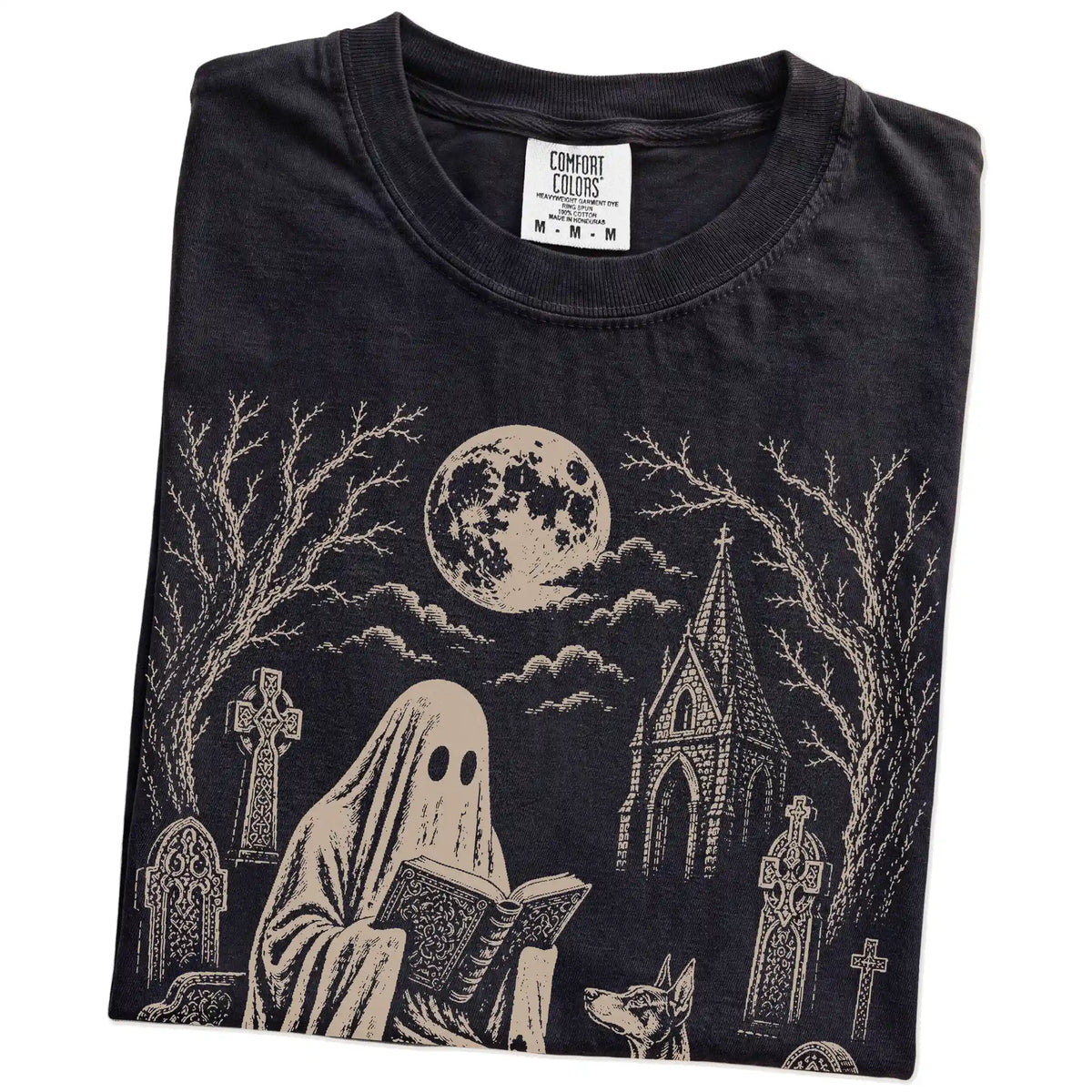 Folded Black Comfort Colors® T-shirt showing Doberman beside a reading ghost in a moonlit graveyard
