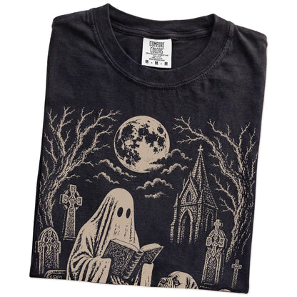 Folded Black Comfort Colors® T-shirt showing Mastiff beside a reading ghost in a moonlit graveyard