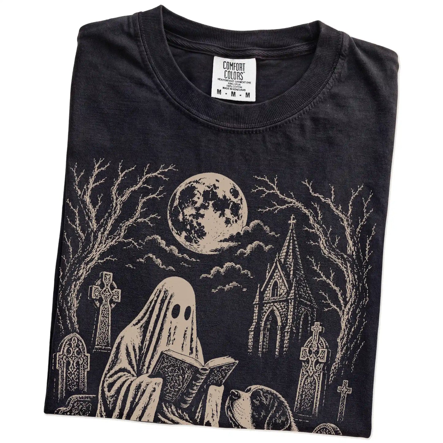 Folded Black Comfort Colors® T-shirt showing Saint Bernard beside a reading ghost in a moonlit graveyard