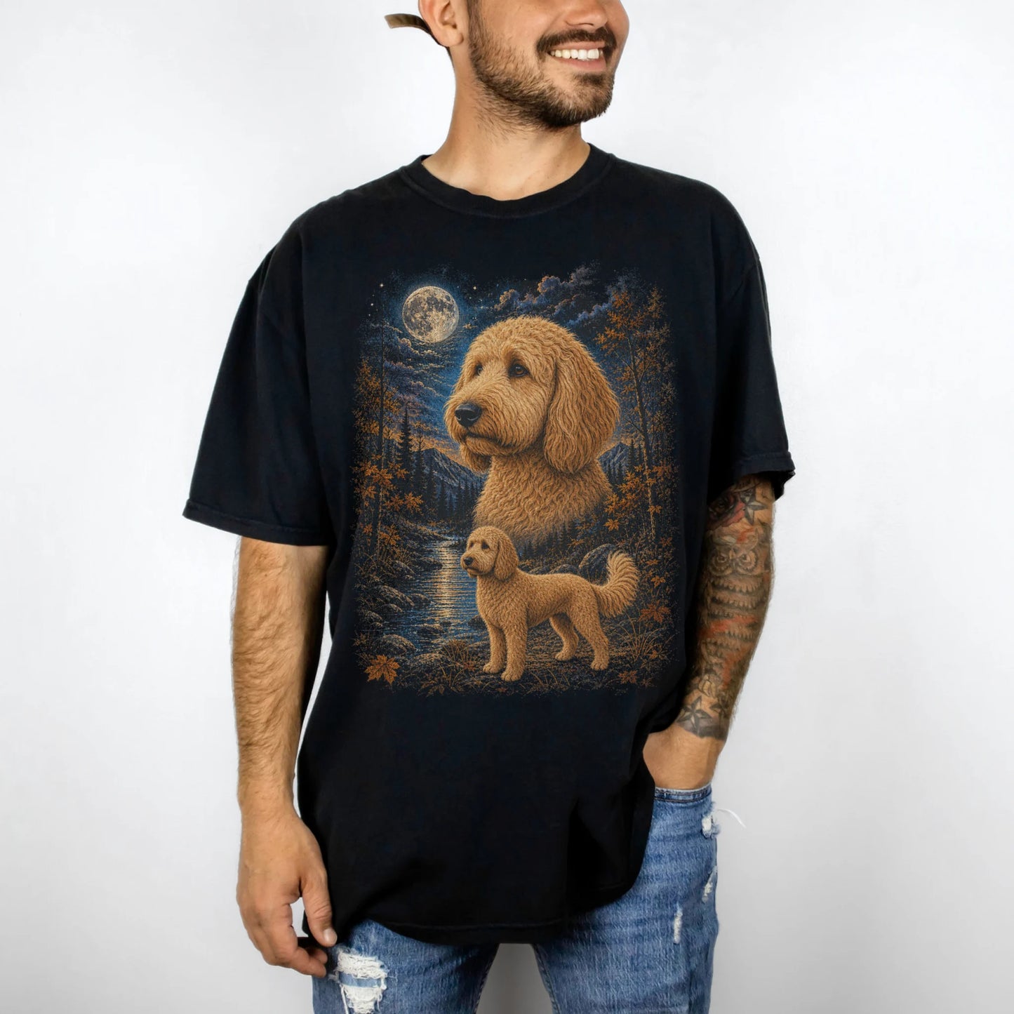 Model wearing a Black Comfort Colors® t-shirt featuring Goldendoodle in a moonlit fall forest