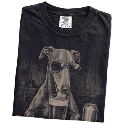 Folded Black Comfort Colors® t-shirt showing Greyhound sneaking a drink from a pint