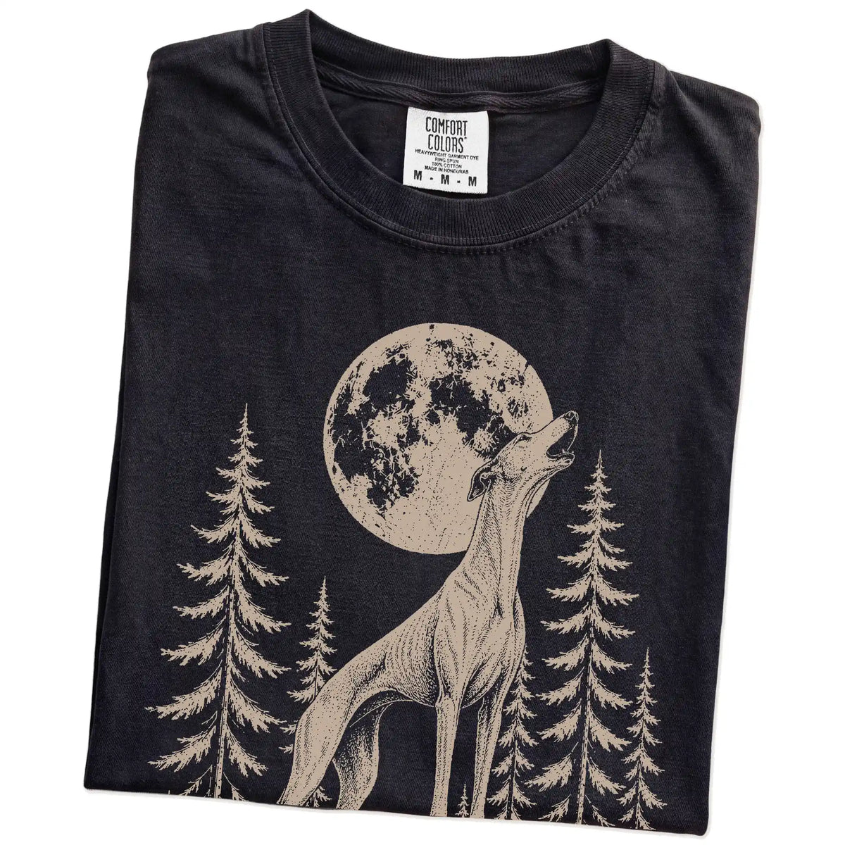 Folded Black Comfort Colors® T-shirt showing a Greyhound howling beneath the moon and pine trees