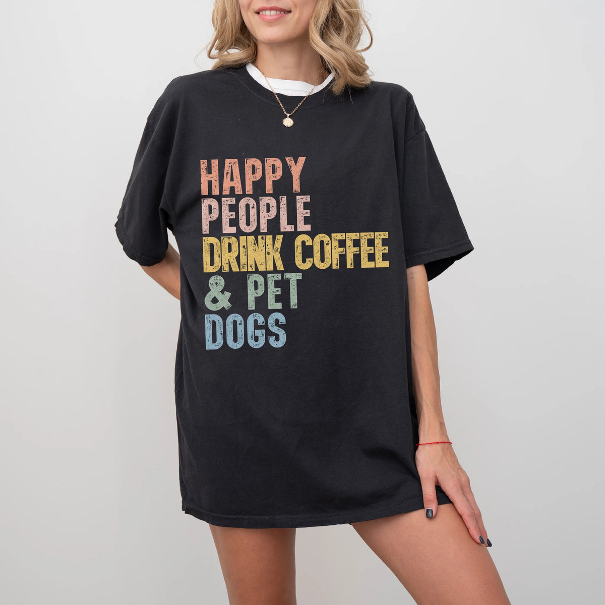 Model wearing a Black Comfort Colors® T-shirt featuring dogs with coffee and “Happy People Drink Coffee and Pet Dogs” letteri