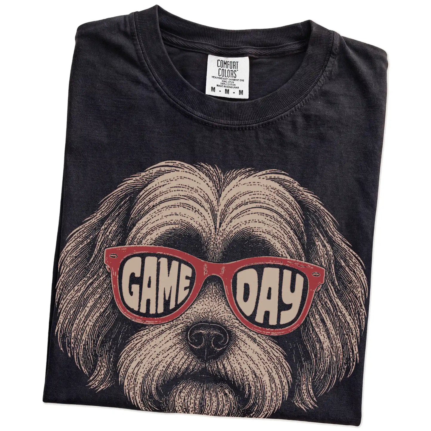 Folded Black Comfort Colors® T-shirt showing havanese wearing red game day sunglasses