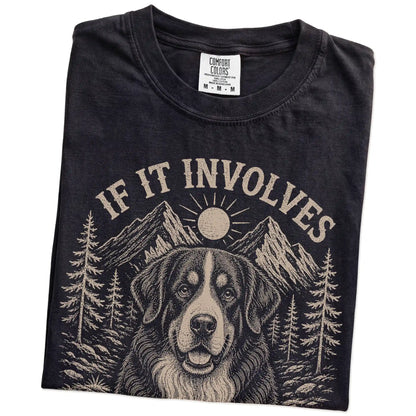Folded Black Comfort Colors® T-shirt showing Bernese Mountain Dog hiking design with mountain scenery