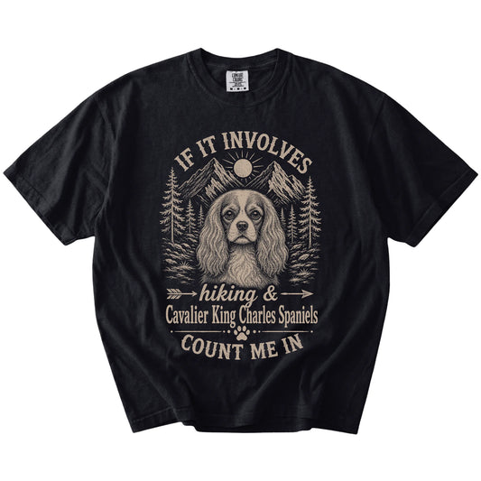 Cavalier King Charles Spaniel hiking design with mountain scenery on a Black Comfort Colors® T-shirt