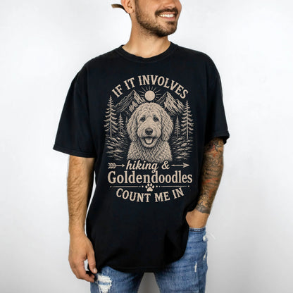 Model wearing a Black Comfort Colors® T-shirt featuring Goldendoodle hiking design with mountain scenery