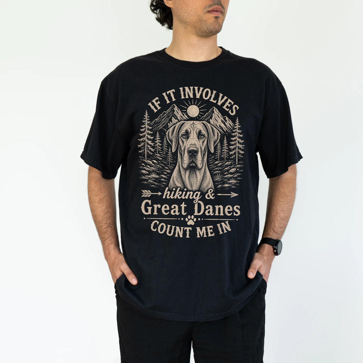 Model wearing a Black Comfort Colors® T-shirt featuring Great Dane hiking design with mountain scenery
