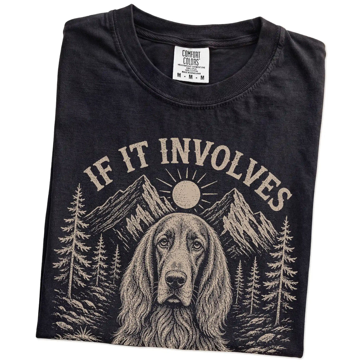 Folded Black Comfort Colors® T-shirt showing Irish Setter hiking design with mountain scenery