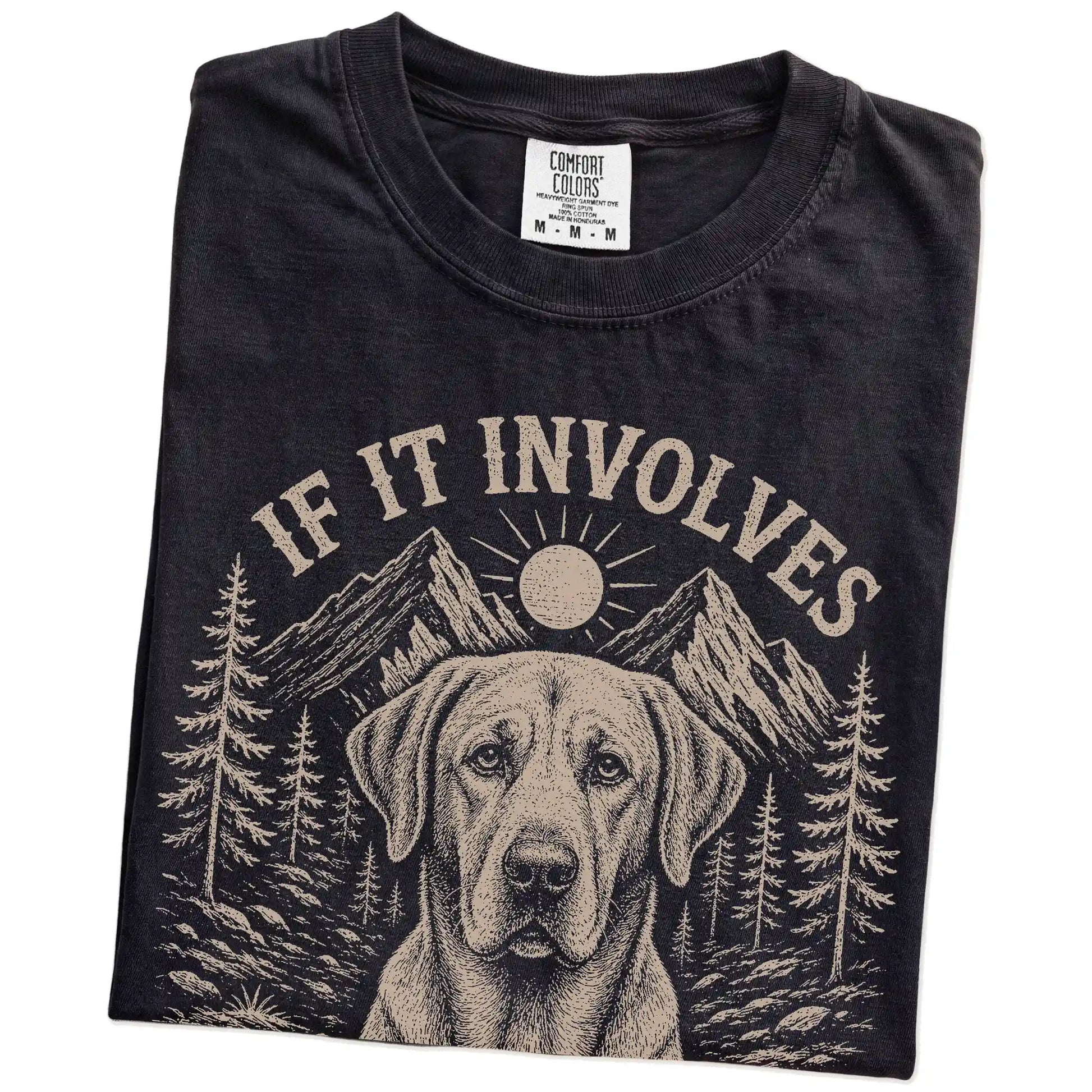 Folded Black Comfort Colors® T-shirt showing Labrador Retriever hiking design with mountain scenery