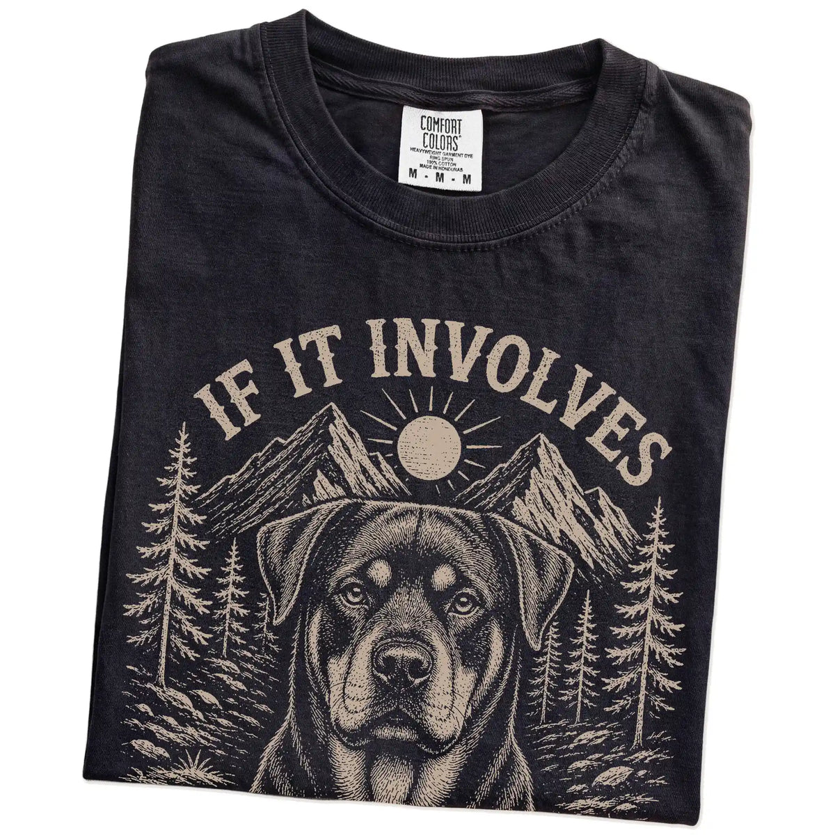 Folded Black Comfort Colors® T-shirt showing Rottweiler hiking design with mountain scenery