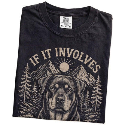Folded Black Comfort Colors® T-shirt showing Rottweiler hiking design with mountain scenery