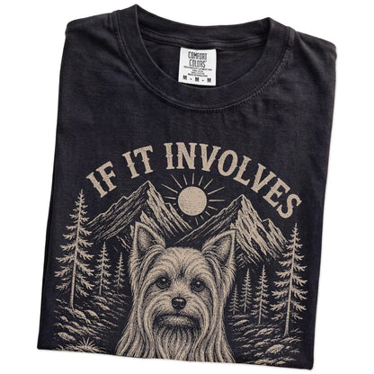 Folded Black Comfort Colors® T-shirt showing Yorkie hiking design with mountain scenery