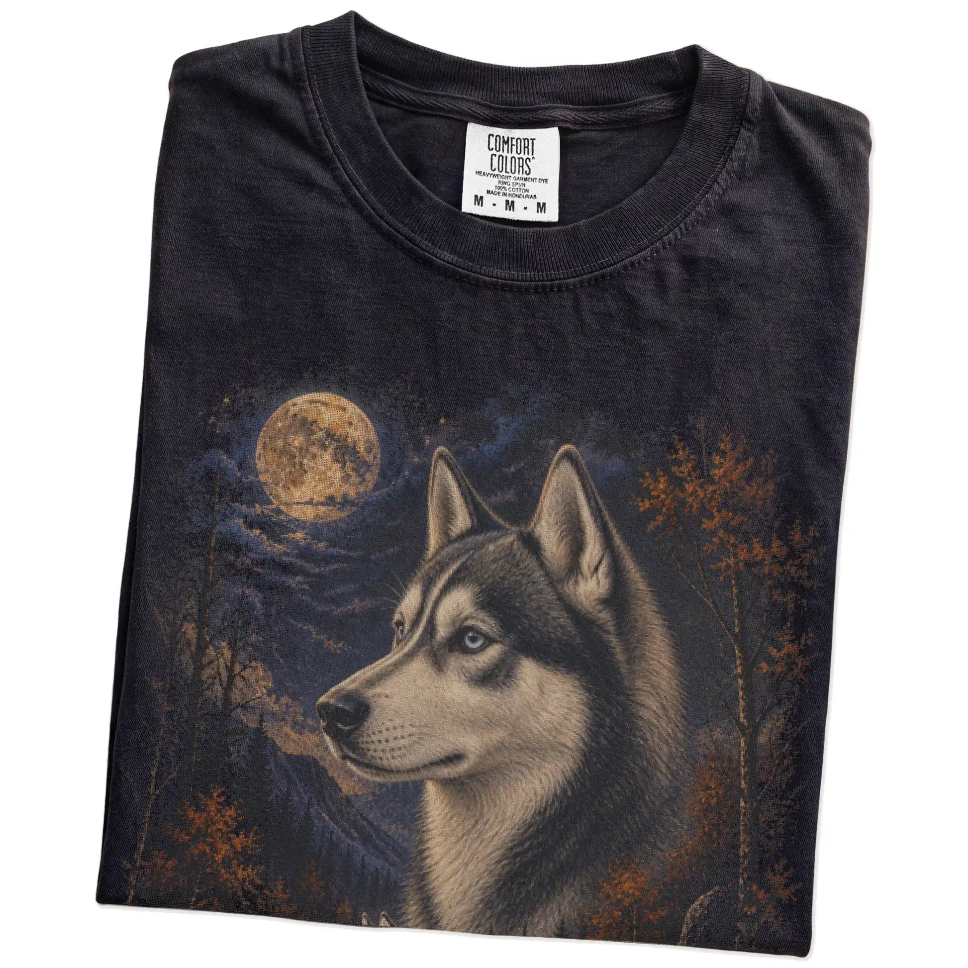 Folded Black Comfort Colors® t-shirt showing Husky in a fall forest graphic