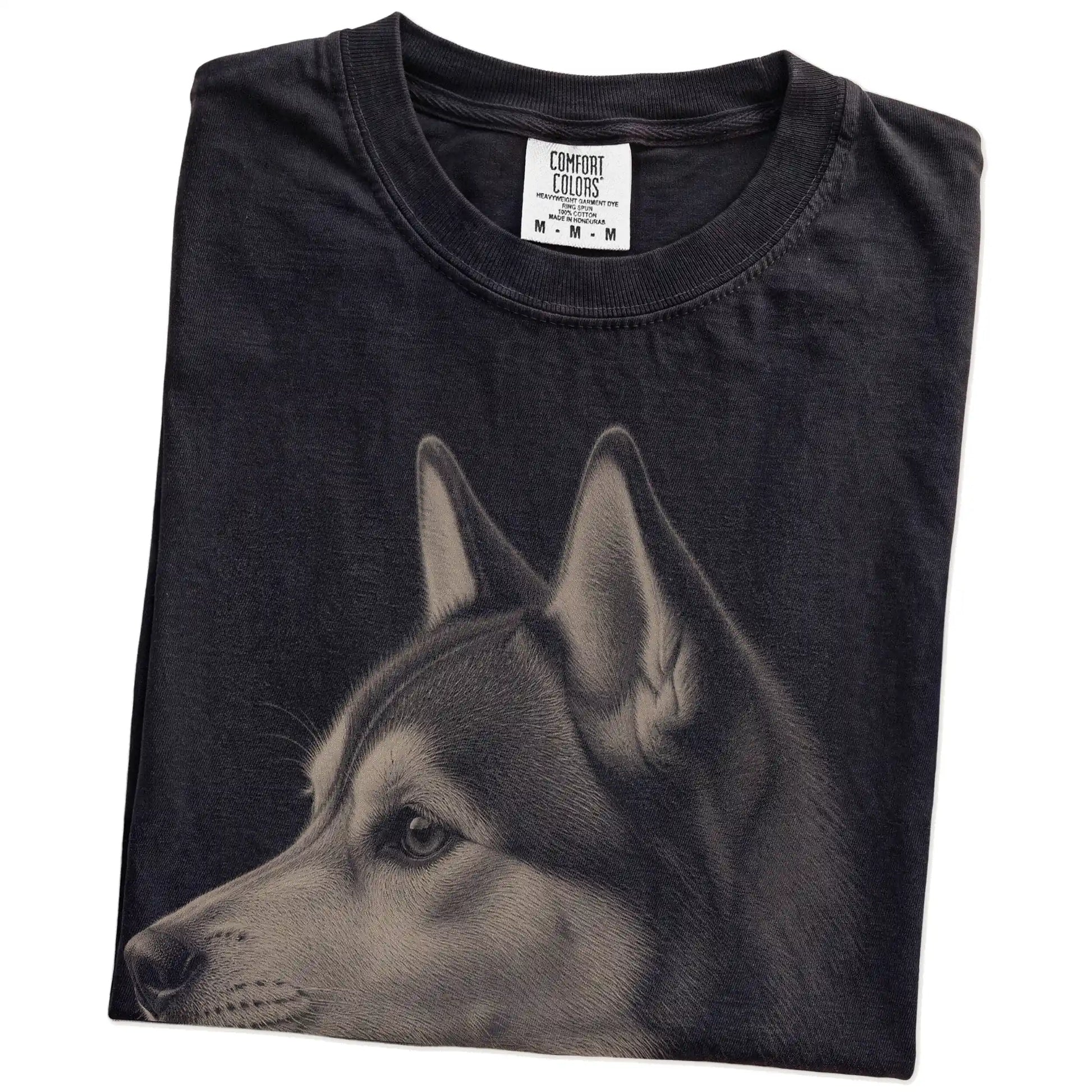 Folded Black Comfort Colors® T-shirt showing a detailed Husky portrait
