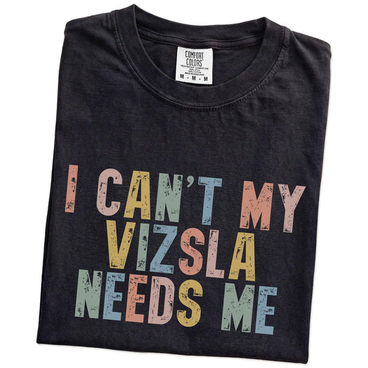 Folded Black Comfort Colors® T-shirt showing Vizsla with “I Can’t, My Dog Needs Me” lettering