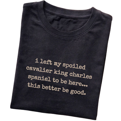 Black I Left My Spoiled Cavalier King Charles Spaniel T-shirt folded to show the printed design