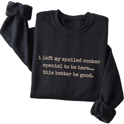 Black I Left My Spoiled Cocker Spaniel sweatshirt folded to show the printed design