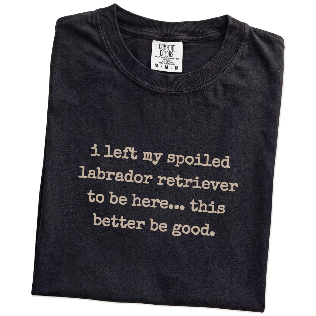 Folded Black Comfort Colors® T-shirt showing the “I Left My Spoiled Labrador Retriever Home” saying