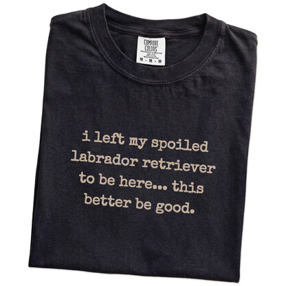 Folded Black Comfort Colors® T-shirt showing the “I Left My Spoiled Labrador Retriever Home” saying