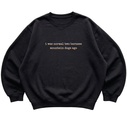 Black I Was Normal Two Bernese Mountain Dogs Ago sweatshirt laid flat