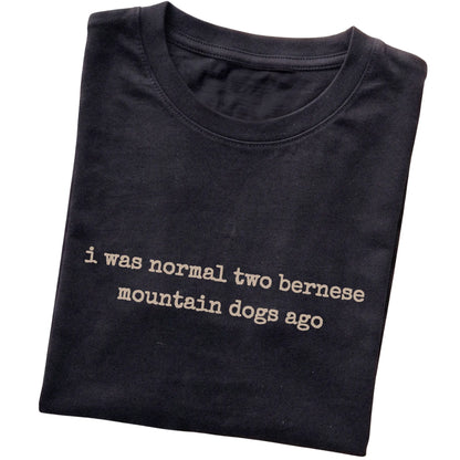 Black I Was Normal Two Bernese Mountain Dogs Ago T-shirt folded to show the printed design