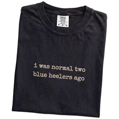 Folded Black Comfort Colors® T-shirt showing i was normal two blue heelers ago lettering